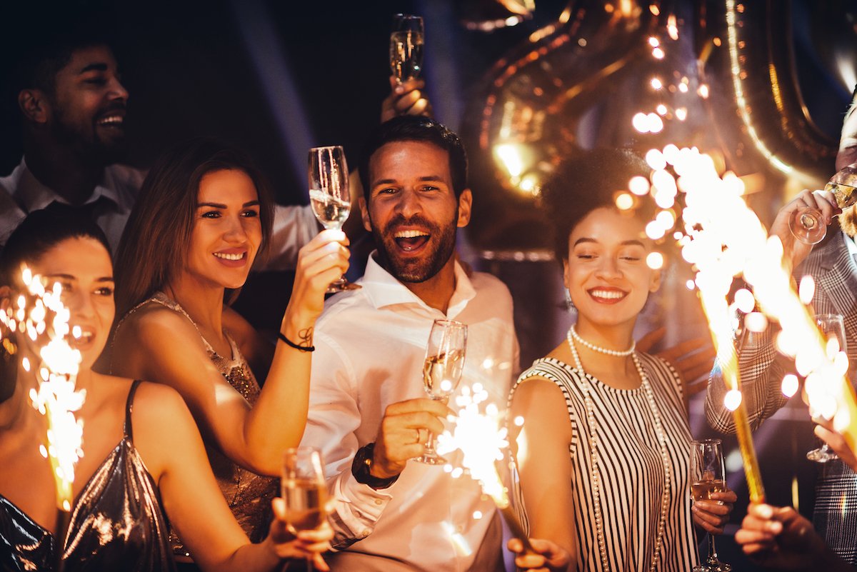 Cropped shot of young friends holding sparklers at a party